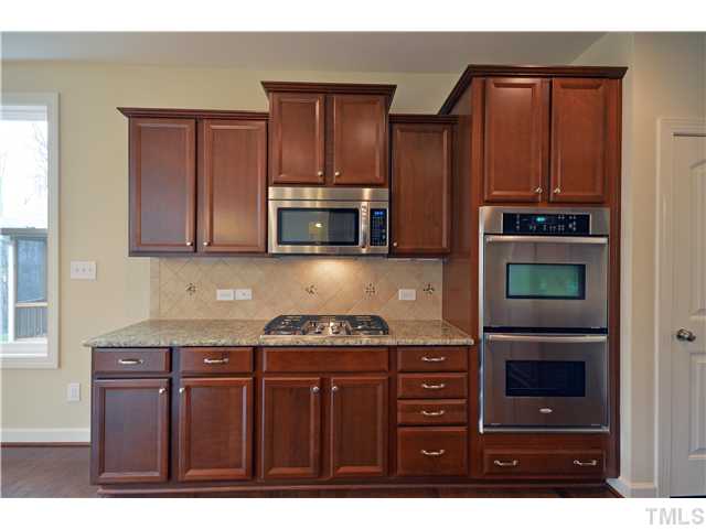 3019 Red Grape Drive Raleigh, NC 27607 - Photo 3 of 22 a kitchen with stainless steel appliances granite countertop a stove and a microwave
