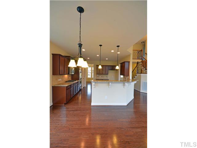 3019 Red Grape Drive Raleigh, NC 27607 - Photo 4 of 22 a view of a kitchen with kitchen island stainless steel appliances a sink and living room view