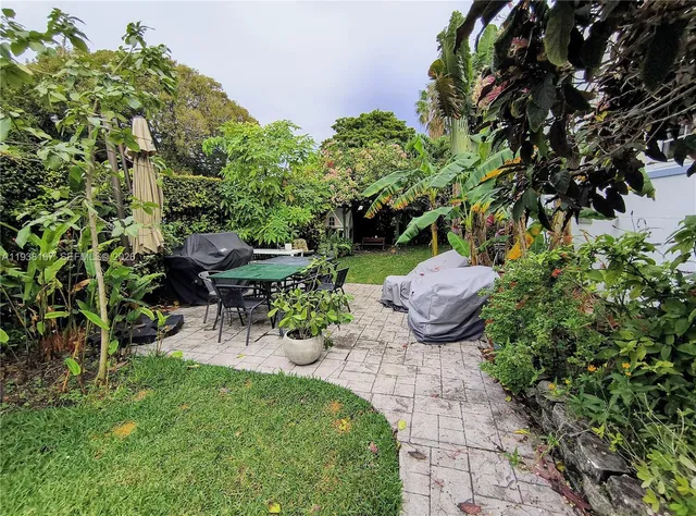 a backyard of a house with table and chairs
