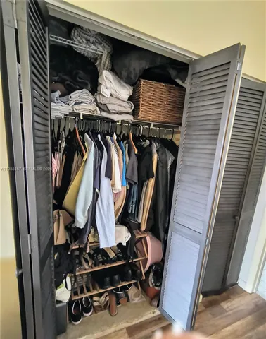 a view of walk in closet with clothes