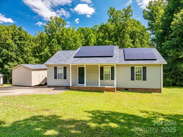 a view of pool with lawn chairs and large trees