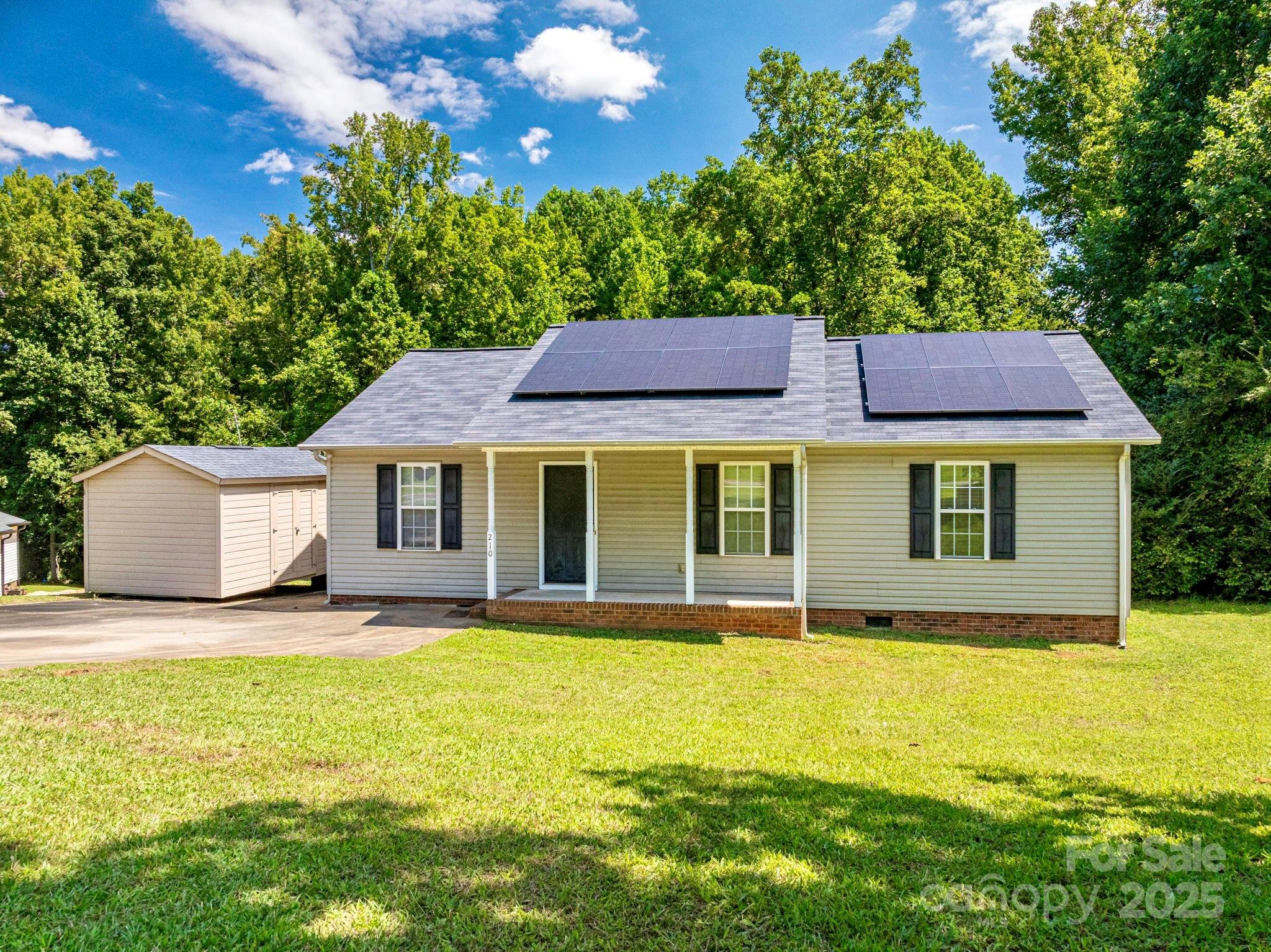 a view of pool with lawn chairs and large trees