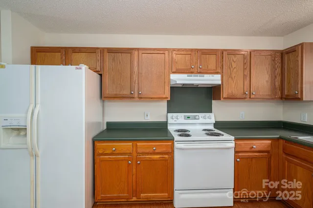 a kitchen with stainless steel appliances granite countertop a refrigerator and a stove