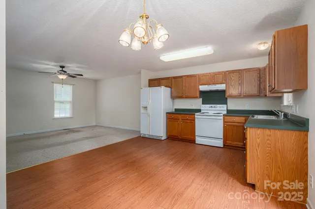 a kitchen with granite countertop a sink cabinets and stainless steel appliances