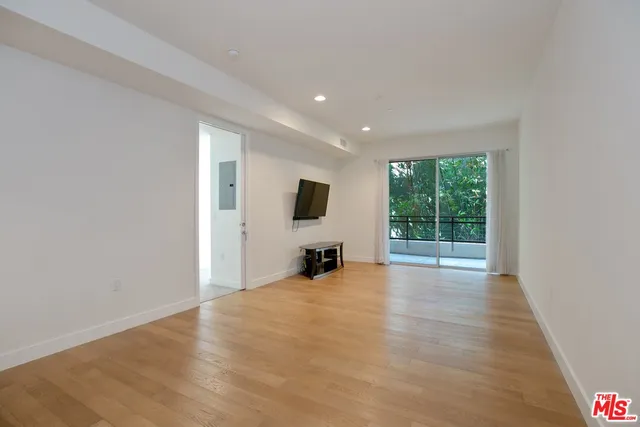 a view of a livingroom with wooden floor and a flat screen tv