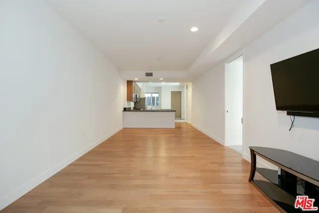 a view of a livingroom with wooden floor and a flat screen tv