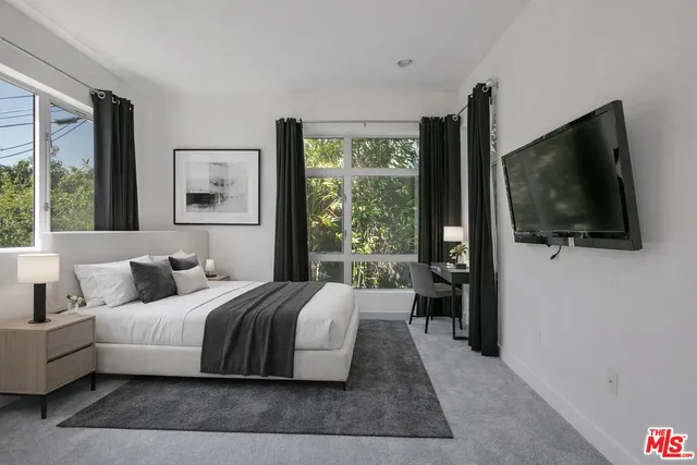 a bedroom with a bed and a flat screen tv