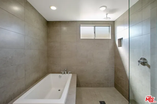 a bathroom with a tub a window and a shower