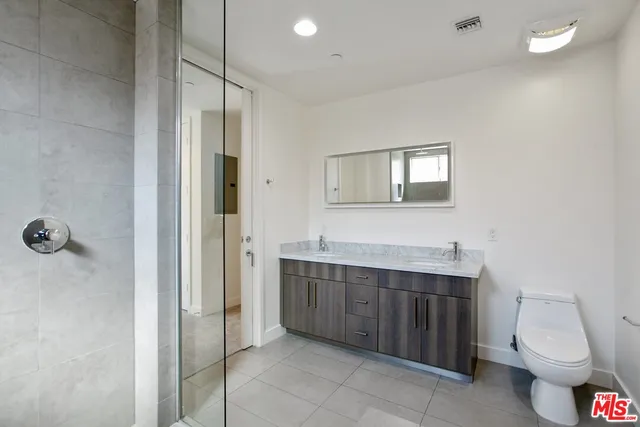 a bathroom with a toilet sink vanity and mirror