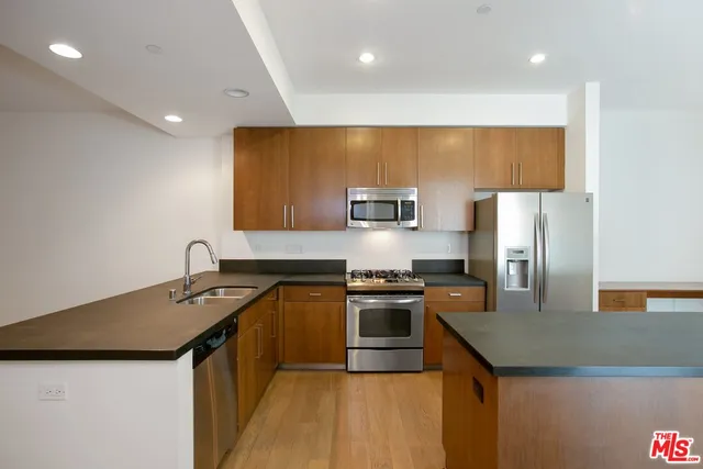 a kitchen with stainless steel appliances granite countertop a sink stove and refrigerator