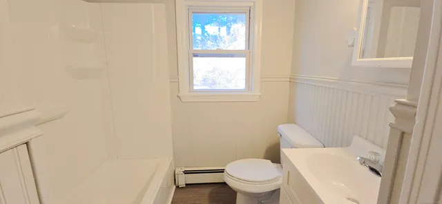 a white toilet sitting next to a window