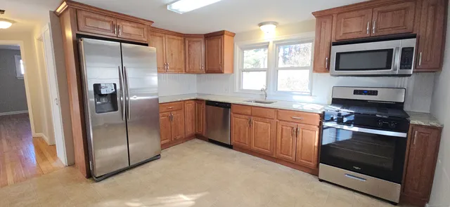 a kitchen with stainless steel appliances granite countertop a refrigerator microwave and sink