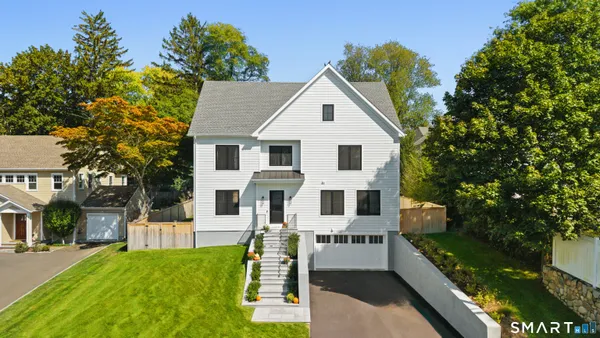 a view of backyard of house with wooden fence and trees