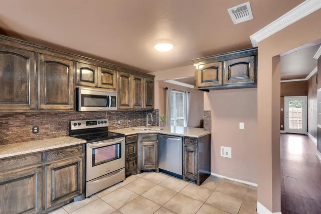 a kitchen with stainless steel appliances granite countertop a stove and a refrigerator