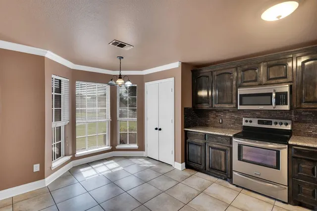 a kitchen with stainless steel appliances granite countertop a refrigerator and a stove top oven