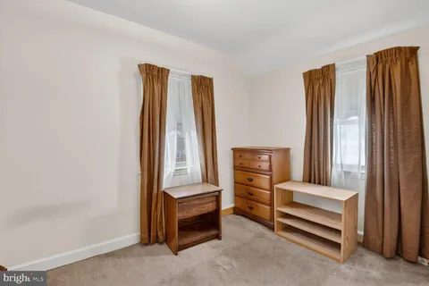 a room with a bed and a refrigerator