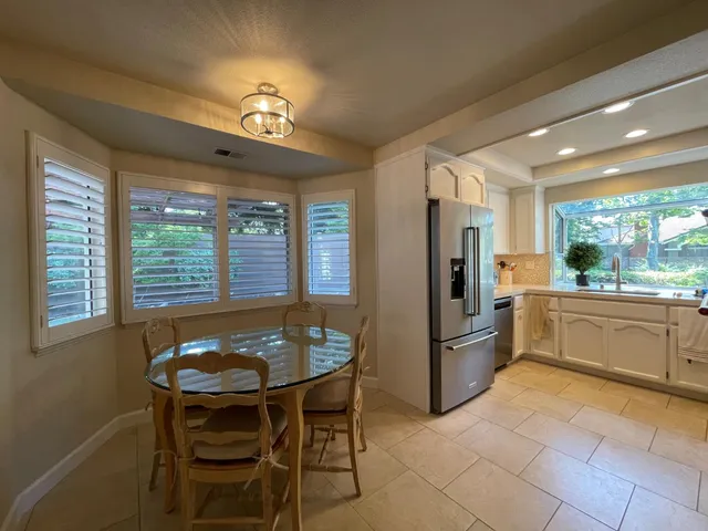 a kitchen with refrigerator and chair