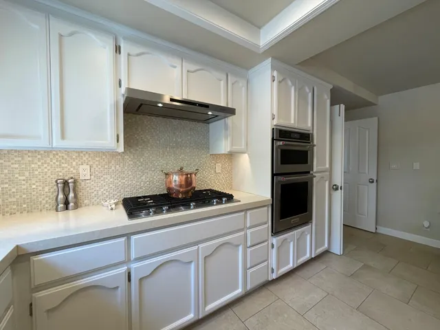 a kitchen with stainless steel appliances granite countertop a sink and a stove