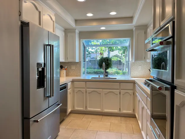 a kitchen with stainless steel appliances granite countertop a refrigerator and a sink