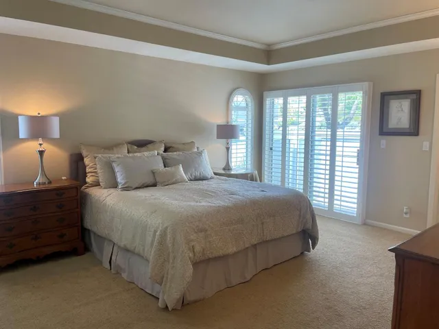 a bedroom with a bed and a large window