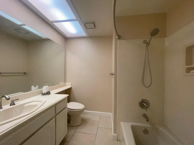 a view of a swimming pool with chairs and table under an umbrella
