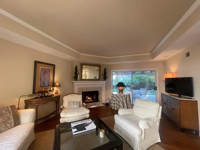 a living room with furniture a flat screen tv and a fireplace