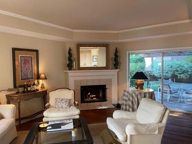 a living room with furniture fireplace and a large window