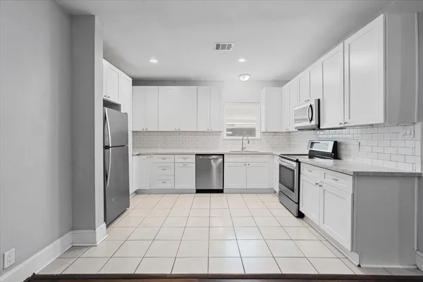 a kitchen with stainless steel appliances a refrigerator sink and cabinets