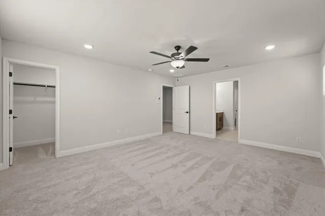 an empty room with a ceiling fan and a window
