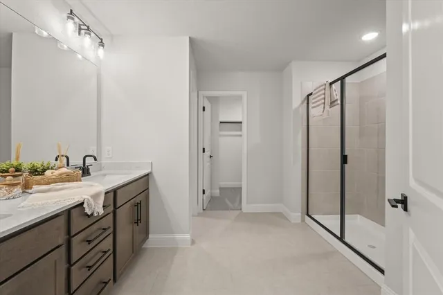 a spacious bathroom with a shower sink vanity and mirror