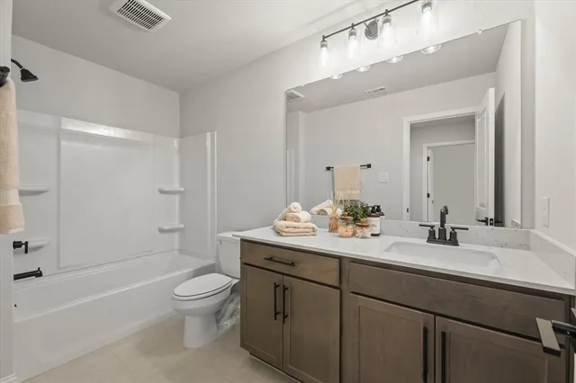 a bathroom with a double vanity sink toilet mirror and bathtub