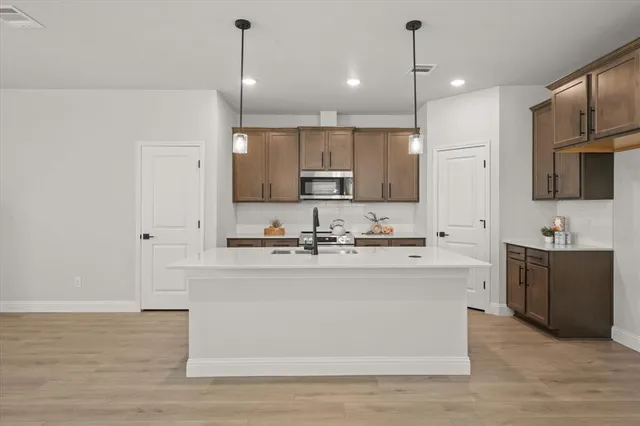 a large kitchen with stainless steel appliances kitchen island a large counter top a sink and a stove