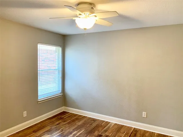 a view of a room with wooden floor and fan