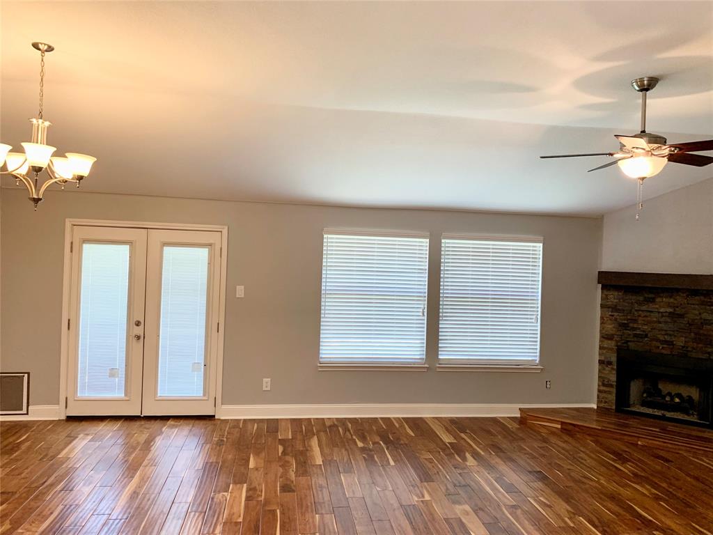 2012 Piper Drive Corinth, TX 76210 - Photo 9 of 27 a view of an empty room with wooden floor fireplace and a window