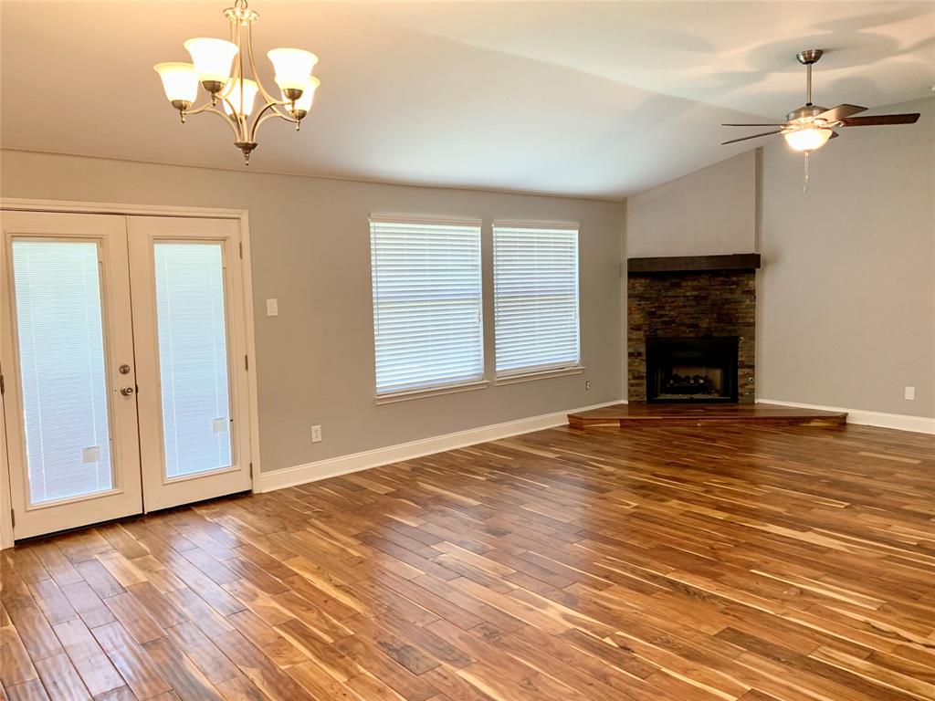 2012 Piper Drive Corinth, TX 76210 - Photo 10 of 27 a view of a livingroom with a chandelier fireplace and wooden floor