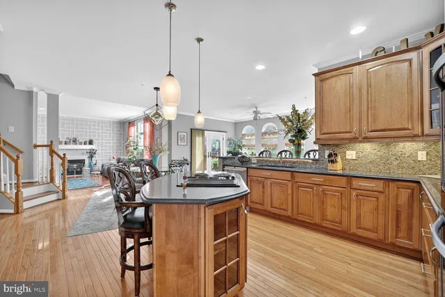 a kitchen with stainless steel appliances a dining table chairs and wooden floor