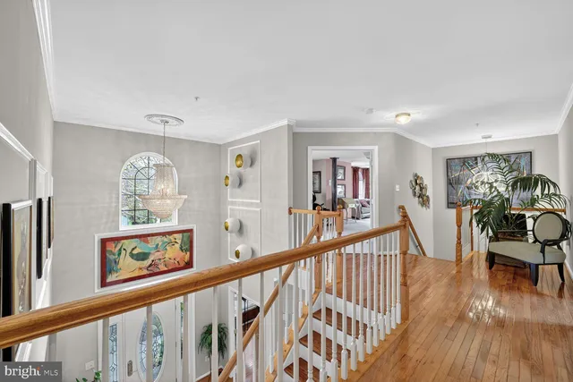 a view of a hallway with wooden floor and stairs