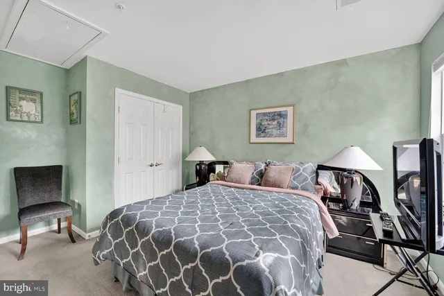 a bedroom with a large bed and a chair