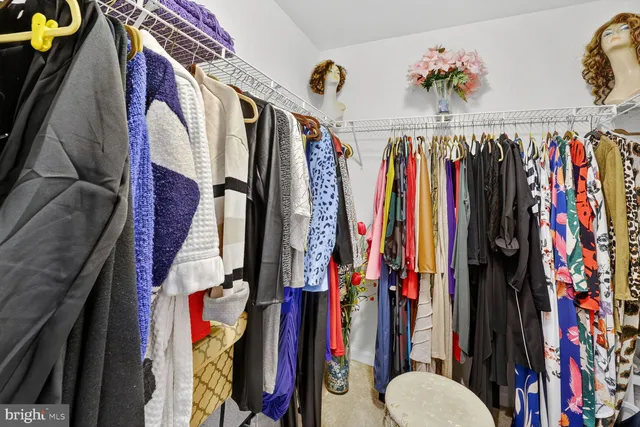a view of walk in closet with clothes and shoes