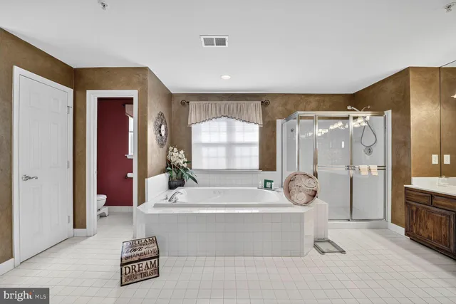 a bathroom with a tub mirror and window