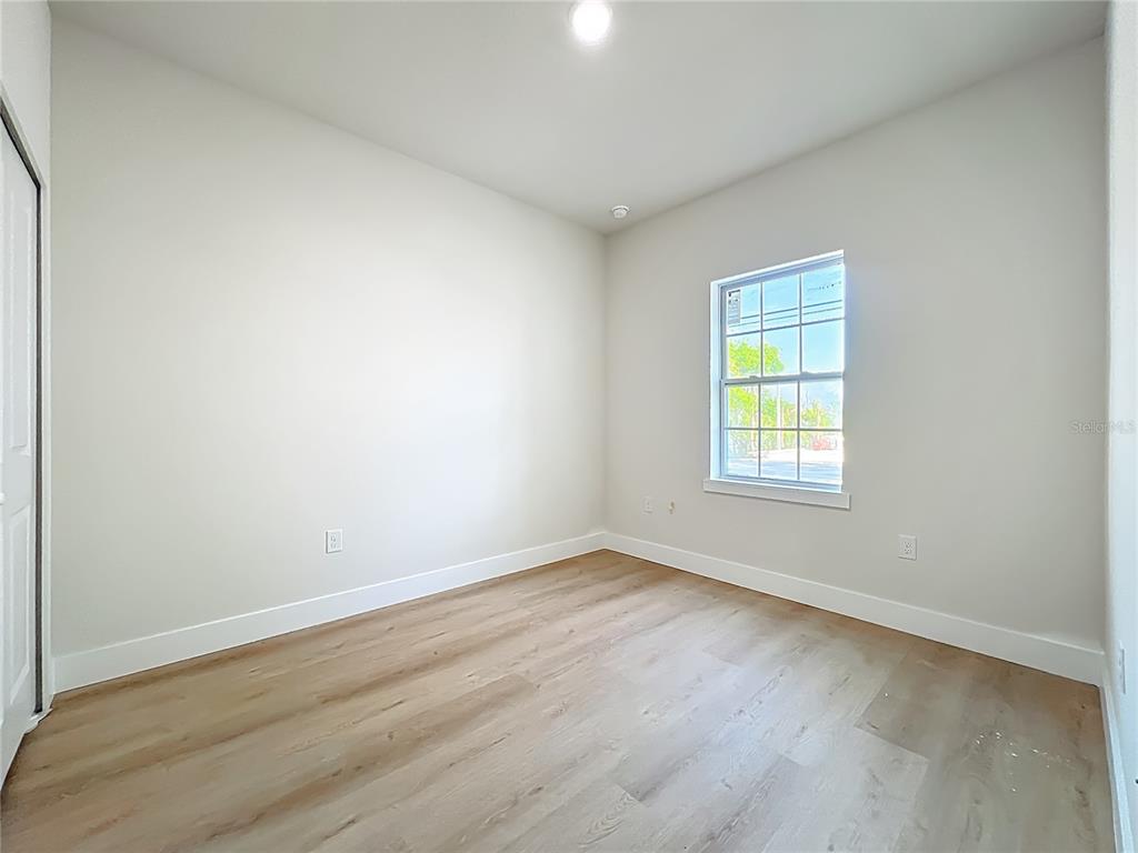 356 West 4th Street Apopka, FL 32703 - Photo 18 of 32 an empty room with wooden floor and windows