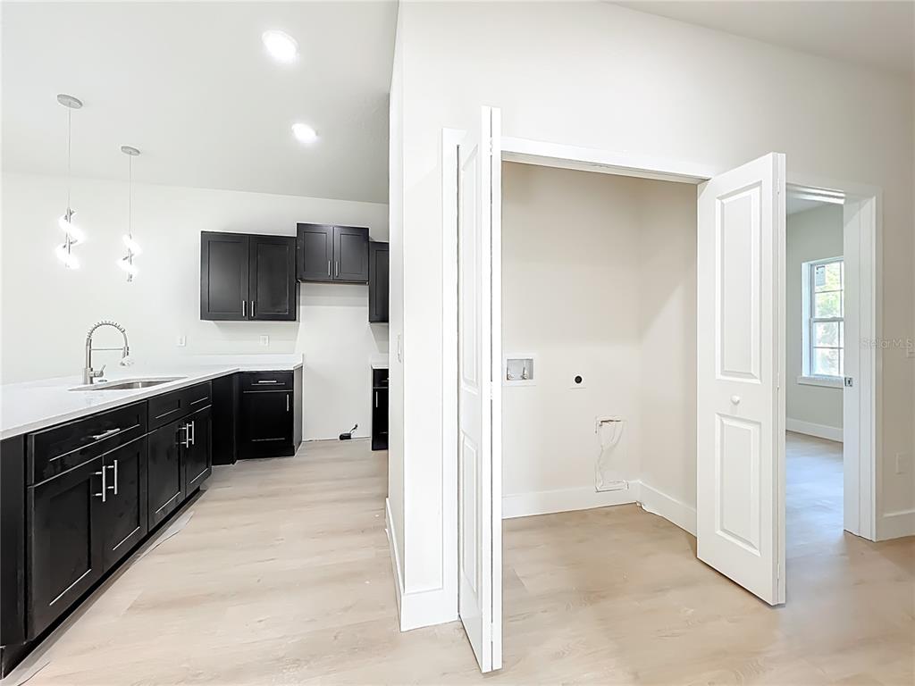 356 West 4th Street Apopka, FL 32703 - Photo 8 of 32 a view of a kitchen with sink a flat screen tv and refrigerator