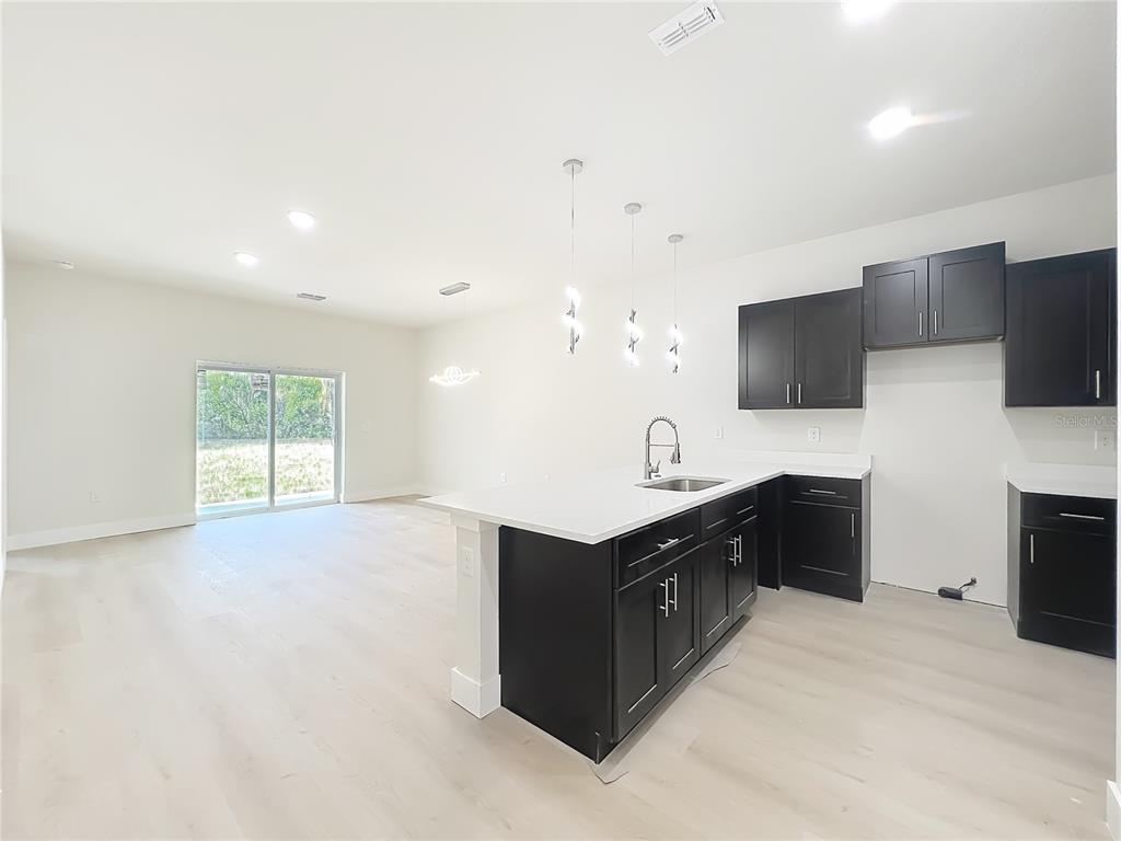 356 West 4th Street Apopka, FL 32703 - Photo 9 of 32 a kitchen with granite countertop a sink and a stove