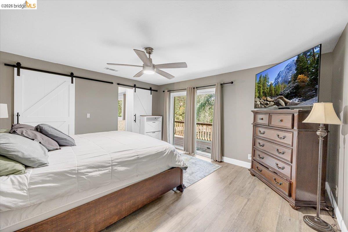 8733 Fraguero Road Sonora, CA 95370 - Photo 41 of 73 Room featuring wood-finish flooring, a ceiling fan with integrated lighting, and a sliding glass door providing outdoor access