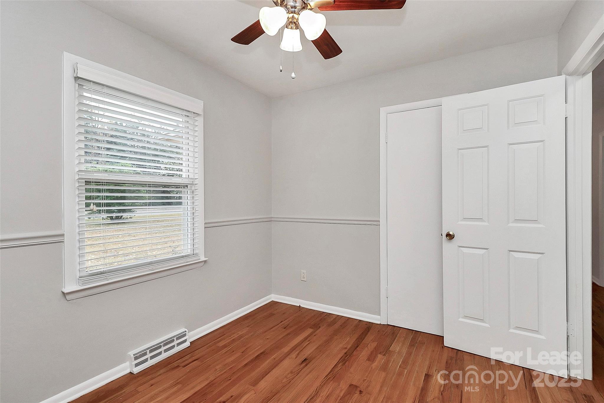 8911 Reames Road Charlotte, NC 28216 - Photo 16 of 31 a view of an empty room with wooden floor and a window