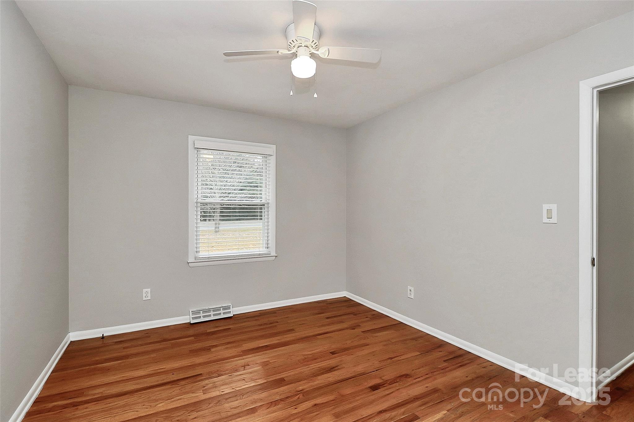 8911 Reames Road Charlotte, NC 28216 - Photo 18 of 31 a view of an empty room with wooden floor and a window