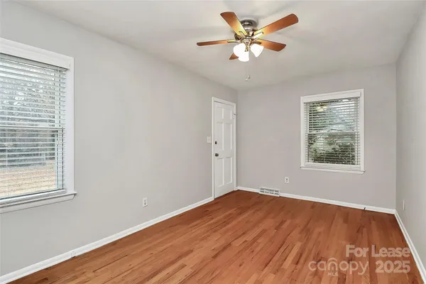 a view of a big room with wooden floor and a window
