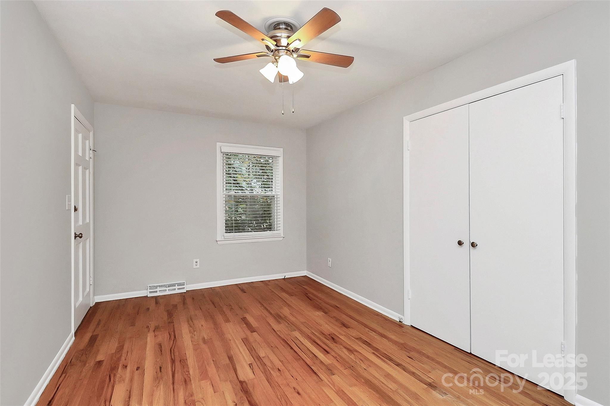 8911 Reames Road Charlotte, NC 28216 - Photo 21 of 31 a view of a room with wooden floor and a ceiling fan