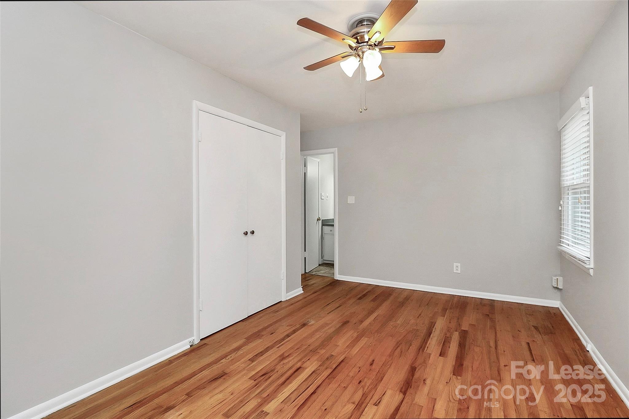 8911 Reames Road Charlotte, NC 28216 - Photo 22 of 31 wooden floor in an empty room with a window