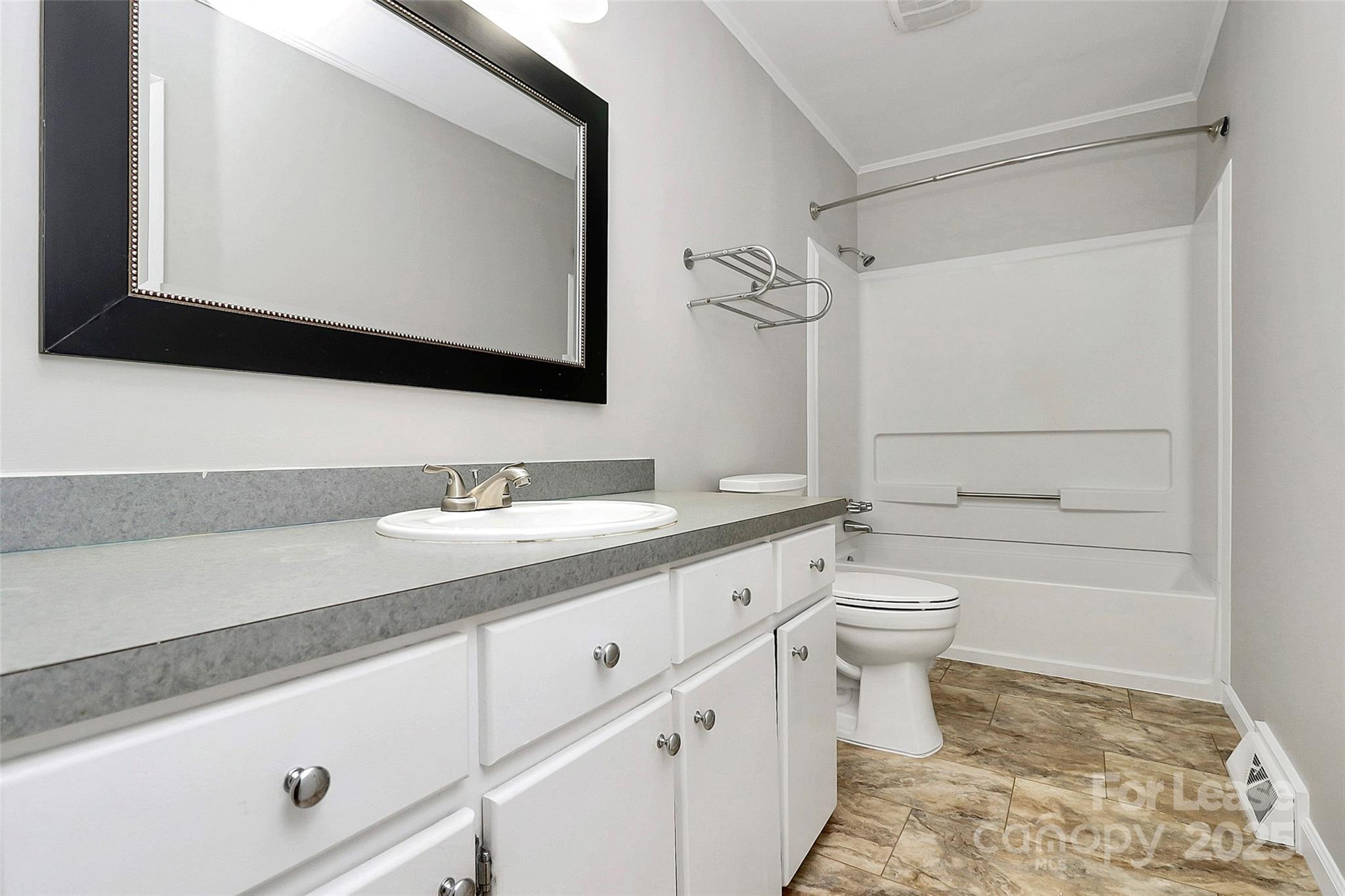 8911 Reames Road Charlotte, NC 28216 - Photo 23 of 31 a bathroom with a granite countertop toilet sink and mirror